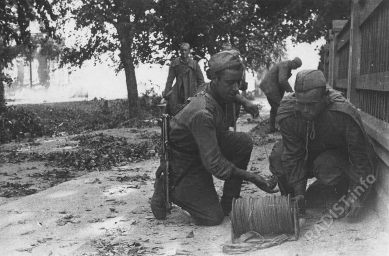 Советские связисты прокладывают линию связи во время уличных боев в Тарту. Эстония, август 1944 г.