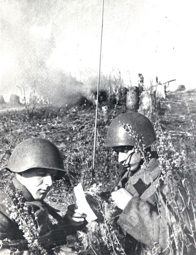 Радисты ст. сержант А. Яковенко (слева) и красноармеец Д. Черноусов за работой на рации на поле боя, 16 октября 1941 г.